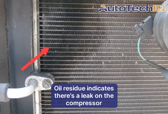 Refrigerant fluid droplets around the AC compressor indicate a freon leak