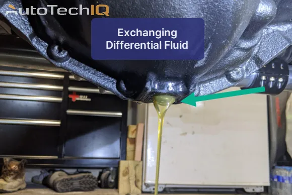 Close-up view of the process of draining old oil from a vehicle differential for a fluid exchange